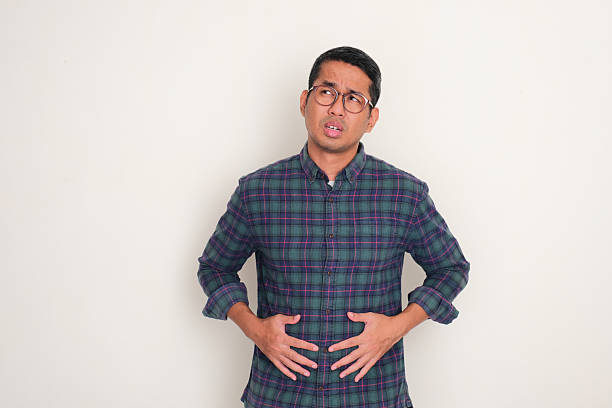 istock A man touching his stomach showing hungry face expression 2203703897