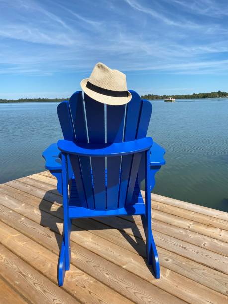 istock Blue Adirondack Chair On Dock By Lake 2203706800