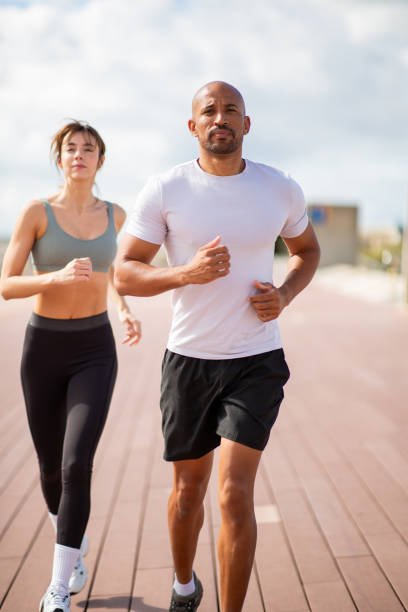 fit and energetic couple running outdoors, showcasing their active lifestyle and dedication to health and wellness