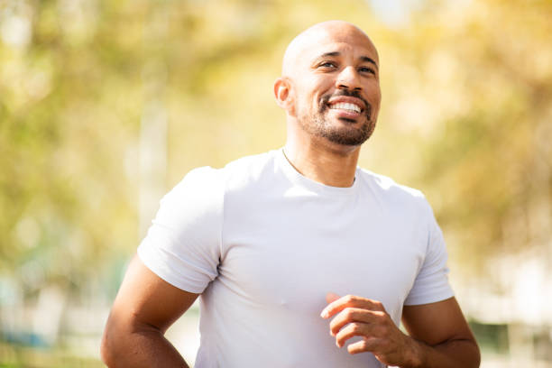 istock man enjoying his run in a sunlit park. 2203712801