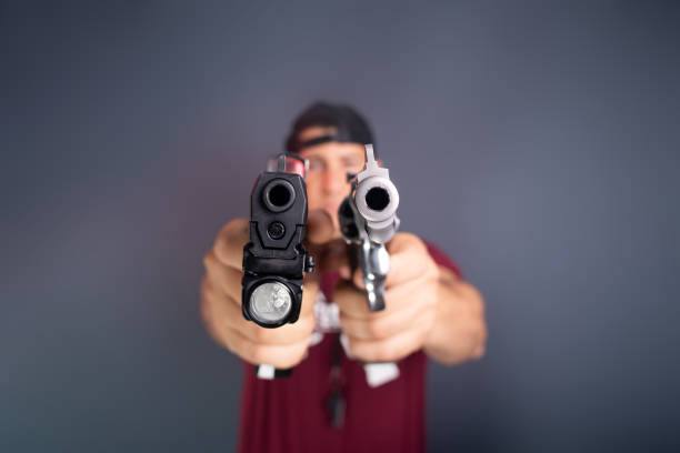 Police officer aiming a handgun towards the camera.