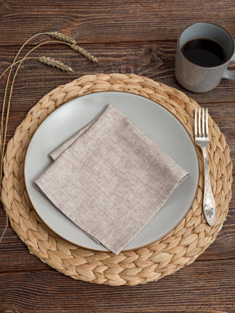 istock Beige napkin on a plate. Serving on a brown wooden table. 2203713653