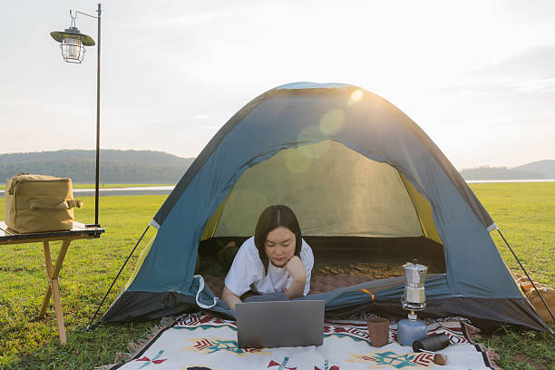 istock Freelance woman working on laptop while camping outdoors 2203715191