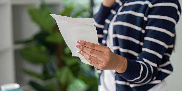 istock Individual reviewing a bill while on a phone call, showcasing financial management. 2203716411