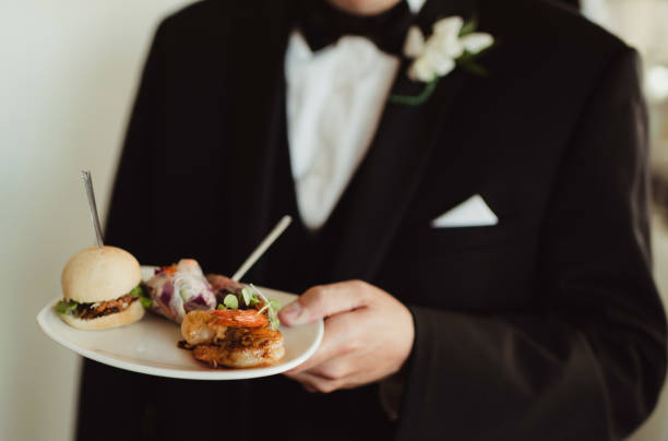 istock Groom at wedding reception holding plate of appetizers 2203720519