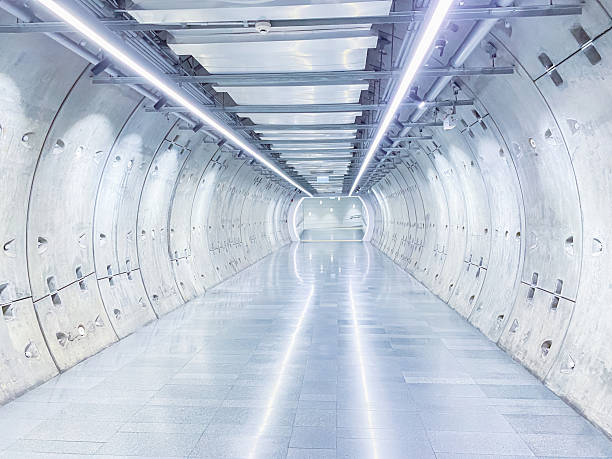 istock Futuristic underground tunnel with curved concrete walls and bright LED lighting. 2203722087