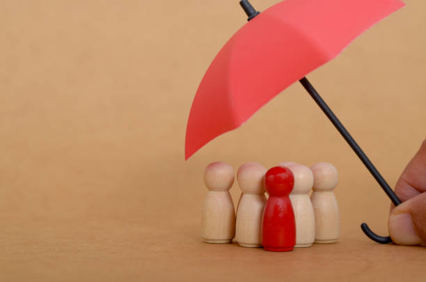 istock Insurance Concept: Red Umbrella Offering Protection to Vulnerable Individuals 2203722183