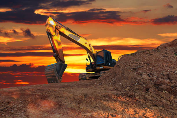istock Yellow  Excavators are digging the soil in the construction site. 2203725328
