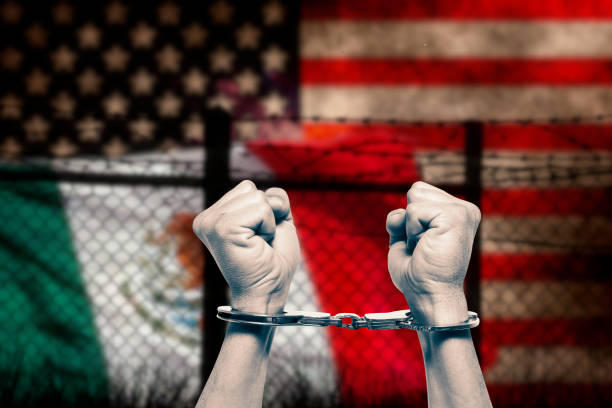 istock Mexican-American border and hands bound with handcuffs 2203726717