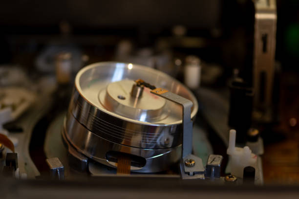 Close-up of a vintage reel-to-reel tape recorder with two reels, showcasing the intricate details of the tape and controls.