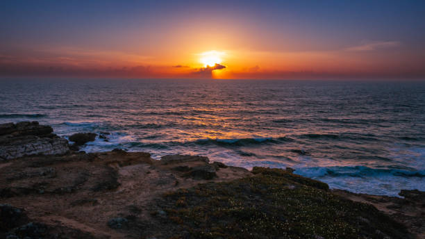 Aerial view over beautiful  ocean during  sunset. Top view to the ocean in summer day while sunset - closeup. Drone view of a Scenic slow motion ocean waves. Beautiful sunrise over ocean