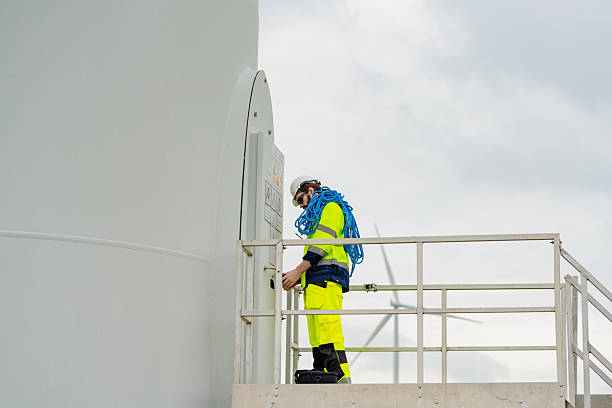 istock Worker performs maintenance on a wind turbine at a renewable energy facility on a cloudy day 2203729106