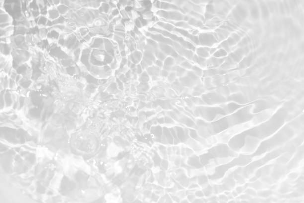 istock White water with ripples on the surface. Defocus blurred transparent white colored clear calm water surface texture with splashes and bubbles. Water waves with shining pattern texture background. 2203729613