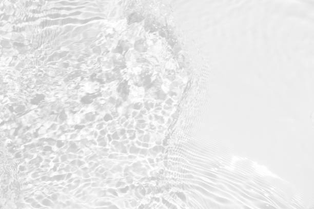 istock White water with ripples on the surface. Defocus blurred transparent white colored clear calm water surface texture with splashes and bubbles. Water waves with shining pattern texture background. 2203729621