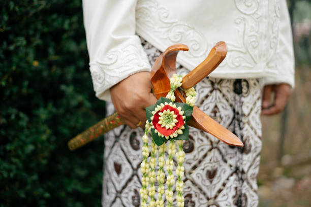 Javanese man holding keris as an accessories on traditional wedding ceremony