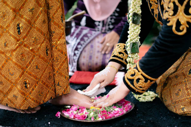 istock A bride wiping groom's foot on traditional Javanese wedding procession 2203730234