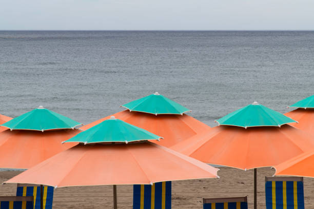 Seascape with beach umbrellas at sunset.\nBol - Brac Islan - Croatia.