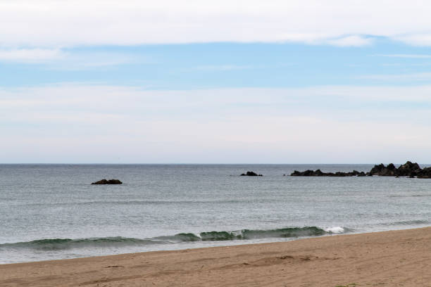 istock surf on the sand beach on a cloudy day 2203733656