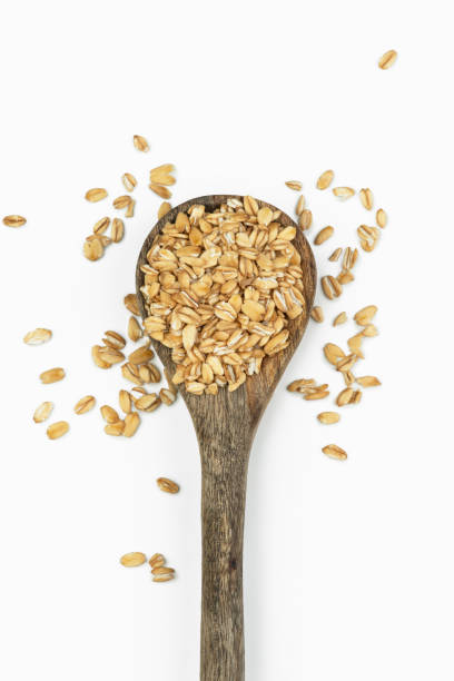 istock Oat flakes in a spoon on a white background 2203739933