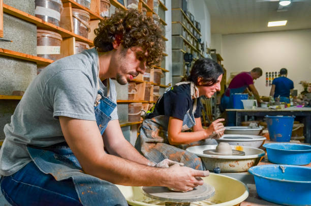 istock Potters molding clay on pottery wheels in workshop 2203741312
