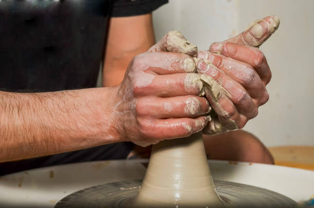istock Potter creating a clay vase on a pottery wheel 2203741384