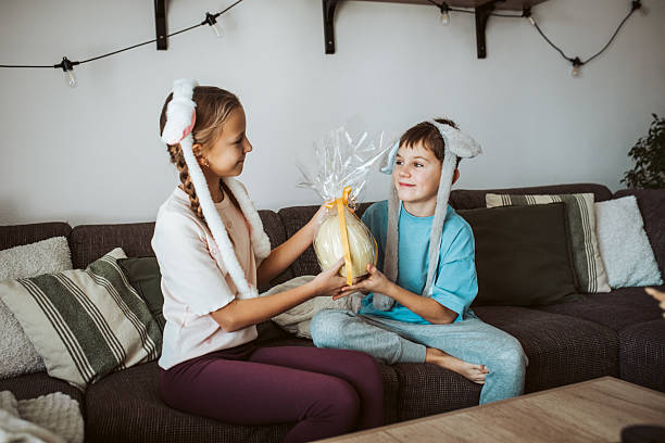 istock Little girl gifting large Easter egg to young boy. 2203741538