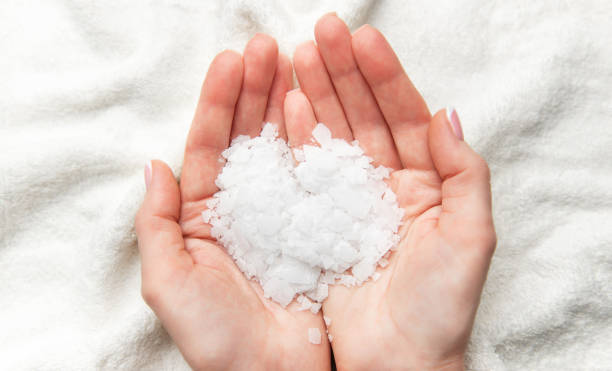istock Woman holding white magnesium chloride flakes in hands for a relaxing bath 2203741663