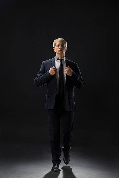 istock confident man strides forward in a dark suit, exuding authority 2203746896