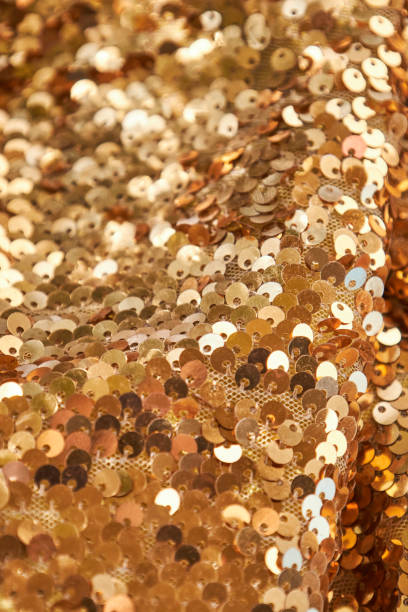 istock Waves of brightly shiny fabric with gold sequins 2203747415