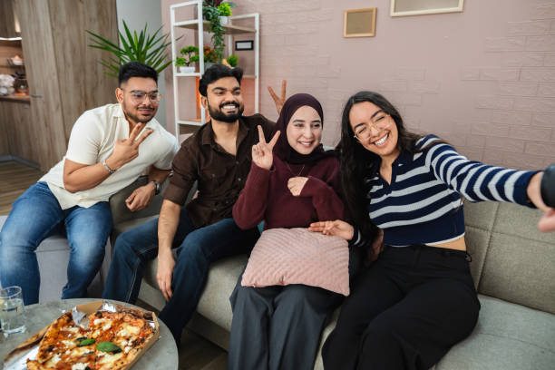 istock Four Young Adults Taking a Selfie While Eating Pizza at Home 2203749943