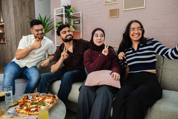 istock Group of friends taking a selfie while eating pizza at home 2203749980