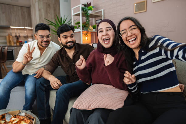 istock Four cheerful friends taking a selfie while watching a movie at home 2203750044