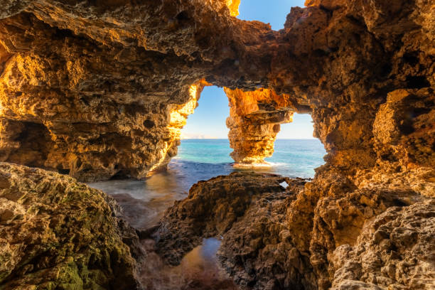 istock Sunlit sea cave with ocean view, rugged cliffs, and crystal waters, Cueva de Los Arcos, Moraig, Spain 2203750305