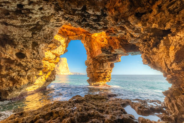 istock Sunlit sea cave with ocean view, rugged cliffs, and crystal waters, Cueva de Los Arcos, Moraig, Spain 2203750307