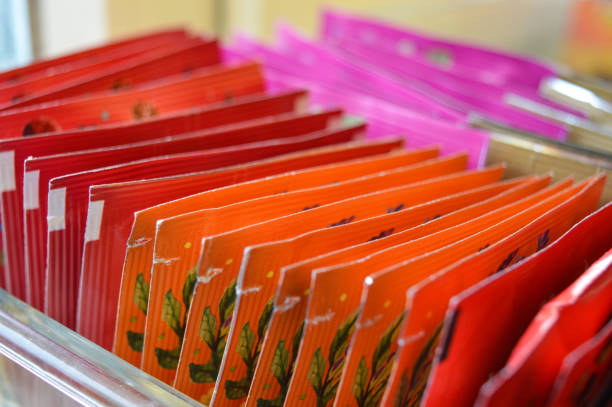 tea bags in a container vibrant red orange pink packaging comfort tea-drinking wellness organization aesthetics color warmth energy daily rituals beauty everyday moments making tea colorful herbal