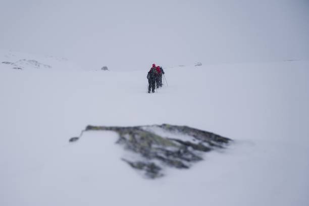 istock Snowshoeing up a white, snow covered mountain 2203753329