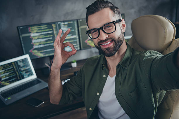 istock Selfie-portrait of successful face web designer sit desk work remote website development improving show okey symbol in workspace 2203754874
