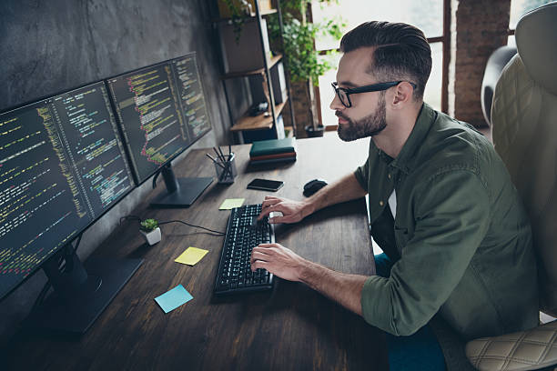 istock Profile side view portrait of attractive focused intellectual guy nerd tech support typing html at work workplace workstation indoors 2203754922