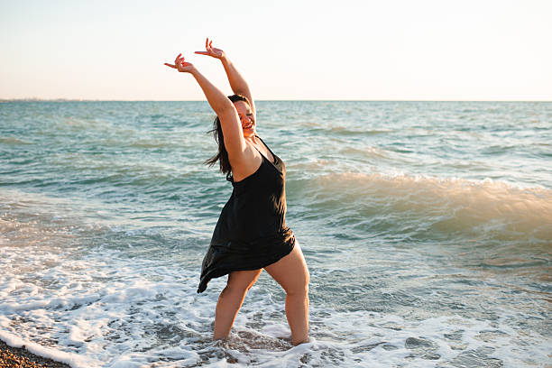 istock Happy woman having fun at beach over sea 2203755241