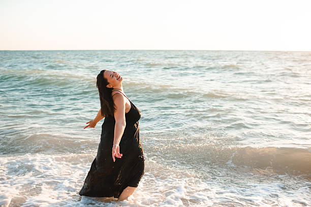 istock Happy woman having fun at beach over sea 2203755253