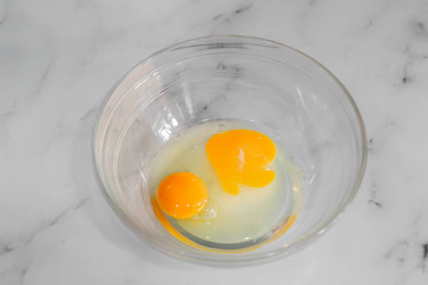 istock Egg yolks in a glass bowl on white marble background 2203758029