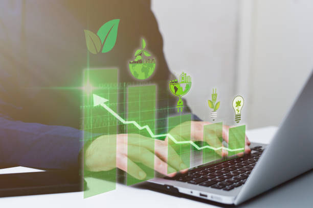 istock Businessman using laptop with green business graph and light bulb on screen 2203758037