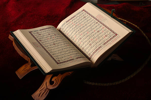 istock Open Quran on Wooden Stand with Prayer Mat Background 2203760449