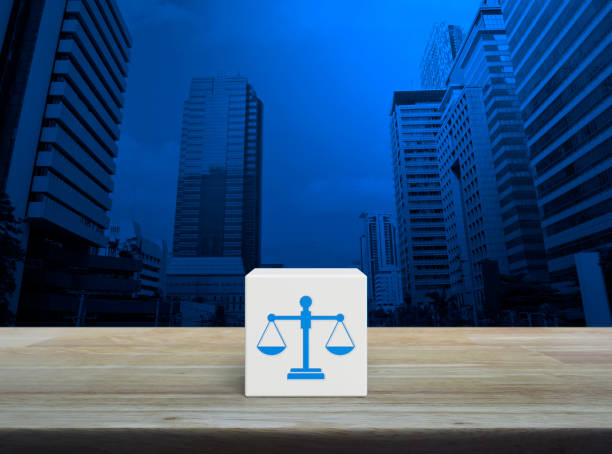 Law flat icon on white block cube on wooden table over modern office city tower and skyscraper, Business legal service concept