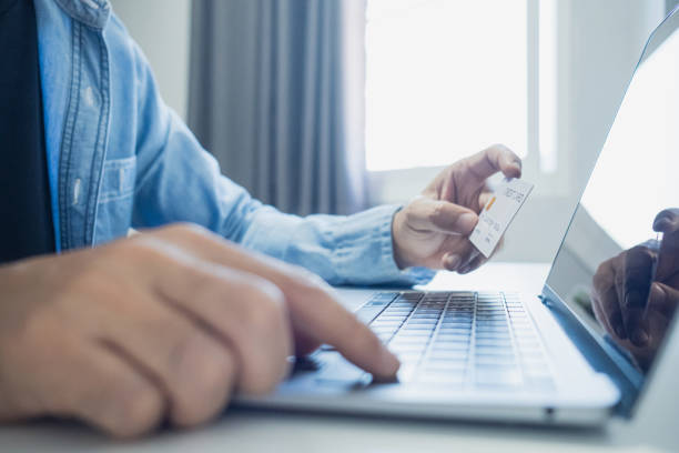 istock Man holding credit card while using laptop, shopping online, buying on internet. e-commerce e-banking service. 2203761857