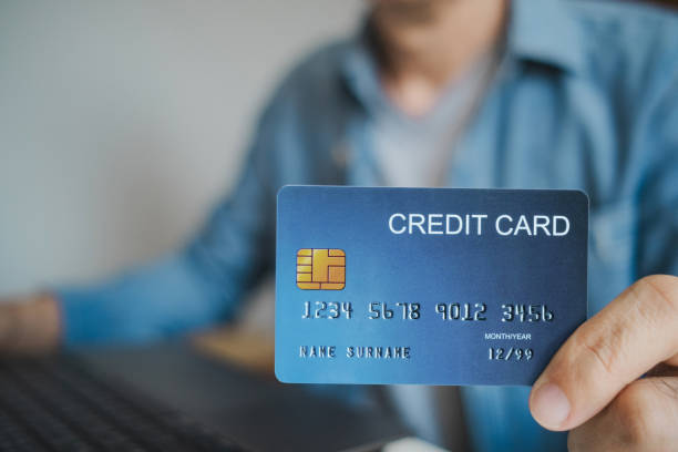 istock Close up, Man holding credit card while using laptop, shopping online, buying on internet. e-commerce e-banking service. 2203761864