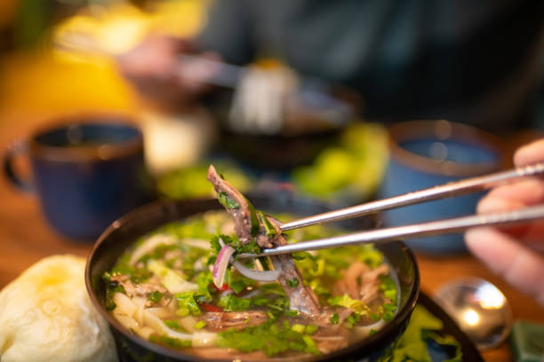 istock People eating Vietnamese dish Pho soup in a cafe 2203762578