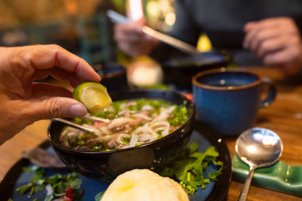 Couple eating Vietnamese dish Pho soup in a cafe