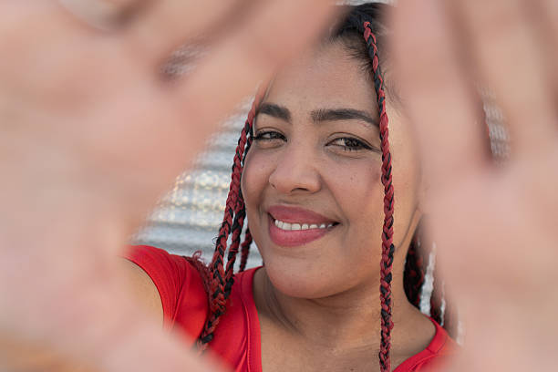 istock Young woman making a heart shape with hands framing her face 2203762710