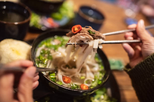 istock Woman eating Vietnamese dish Pho soup in a cafe 2203762743